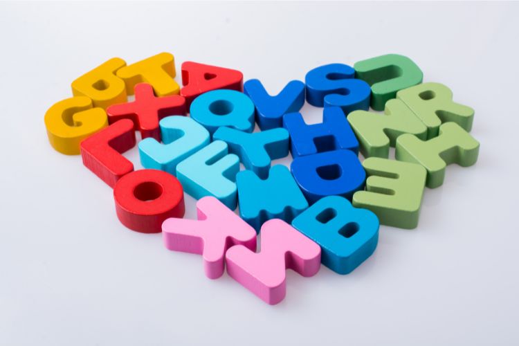 Brightly coloured letters are randomly together in a heart shape